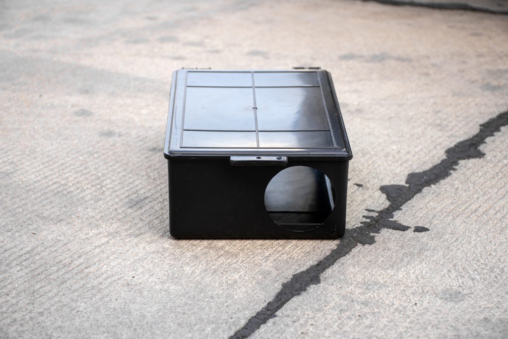 Poison rat trap box on the floor. Outdoor poison rat station in factory.